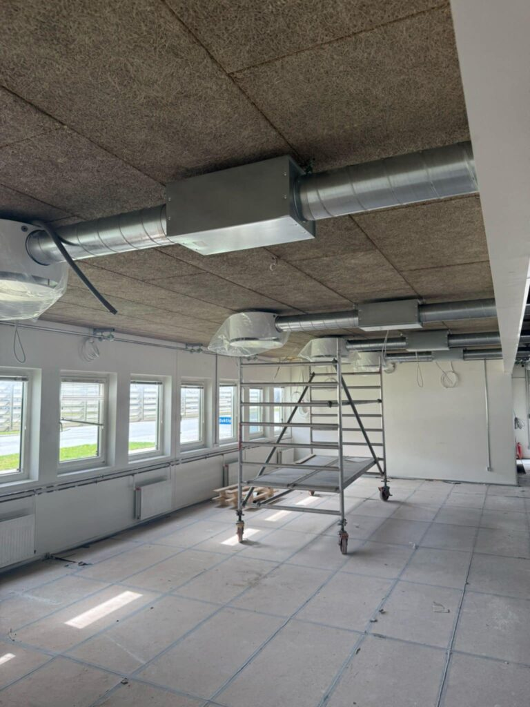 Montage af kanaler fra rullestillads i kontormiljø